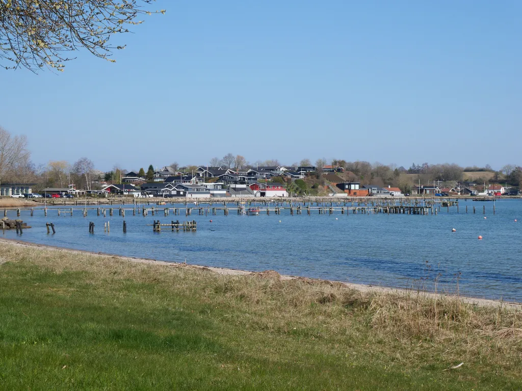 Hinter einem Stand sind einige Häuser eines Küstenorts in Dänemark